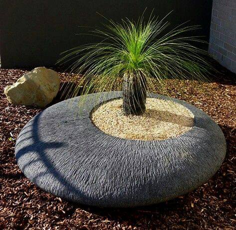 Image 12: low circular concrete garden ring with ornamental grass