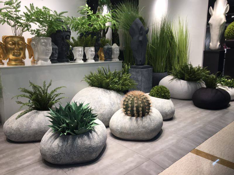 Image 4: gallery-style interior display of rounded stone planters